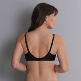 Podprsenka Anita Colette 5248 – černá podprsenka s kosticemi, nastavitelnými ramínky a květinovou krajkou na ramenou, modelka s dlouhými hnědými vlasy zezadu před světle šedým pozadím.