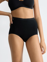 Sloggi Basic+ 10007656 – černé dámské kalhotky s vysokým pasem z balení 3 ks, záběr na trup modelky od pasu po stehna na světlém pozadí.